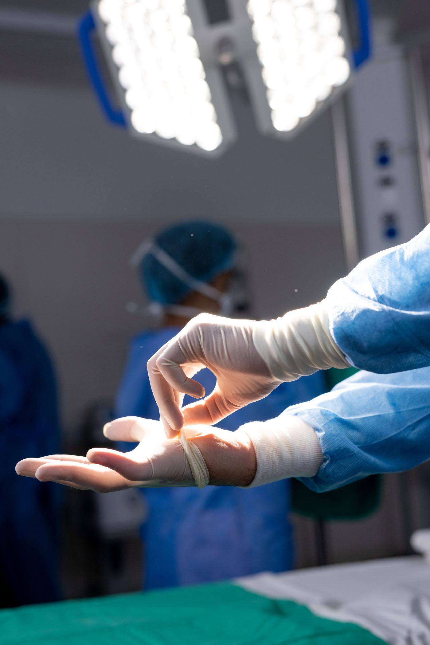 Gloved surgical team in an operating room preparing for hand surgery under theatre lights